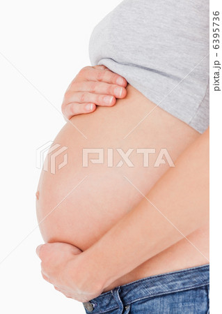 Side view of a pregnant woman caressing her belly while standing Side view of a pregnant woman caressing her belly while standing 6395736