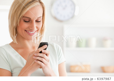 Close up of a cute woman smiling at her mobile Close up of a cute woman smiling at her mobile 6397987