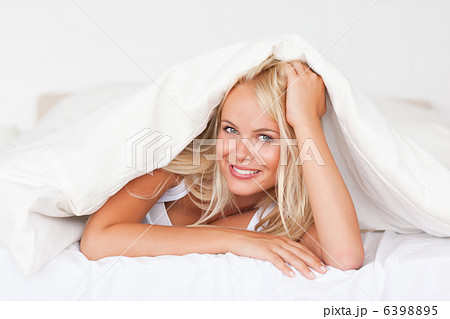 Smiling woman under a duvet 6398895