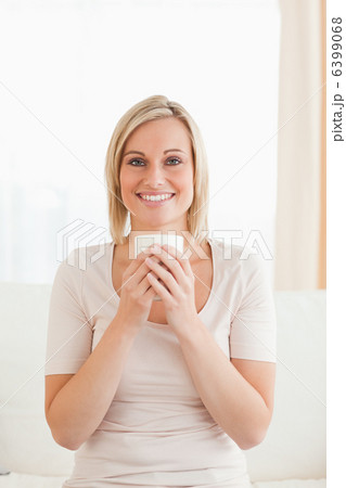 Portrait of a smiling woman holding a cup of tea Portrait of a smiling woman holding a cup of tea 6399068
