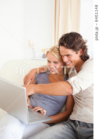 Portrait of a man showing something to his wife on a notebook 6401148