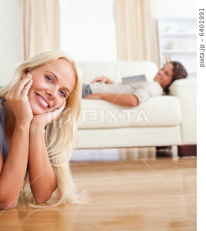 Portrait of a woman lying on the floor while her fiance is with 6401991