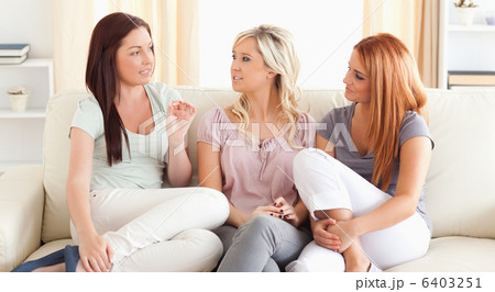 Chatting friends sitting on a sofa Chatting friends sitting on a sofa 6403251