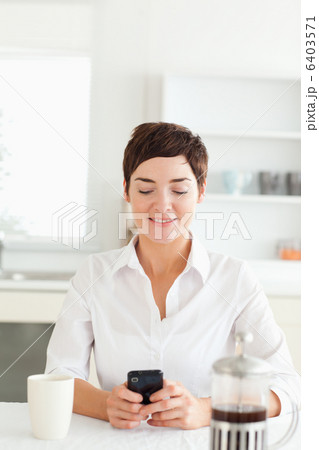Woman with mobile phone and coffee in kitchen 6403571