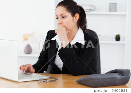 Serious young businesswoman in office 6403681