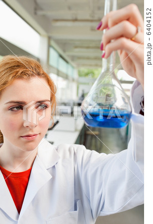 Portrait of a cute science student holding a blue liquid Portrait of a cute science student holding a blue liquid 6404152