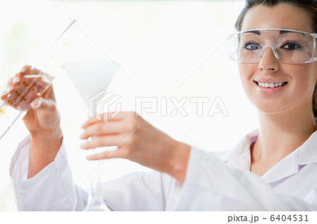 Scientist pouring liquid with a funnel Scientist pouring liquid with a funnel 6404531