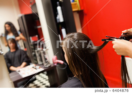 Cute woman having her hair straightened 6404876