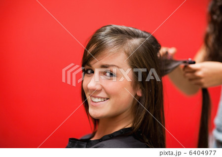 Young woman having her hair straightened 6404977