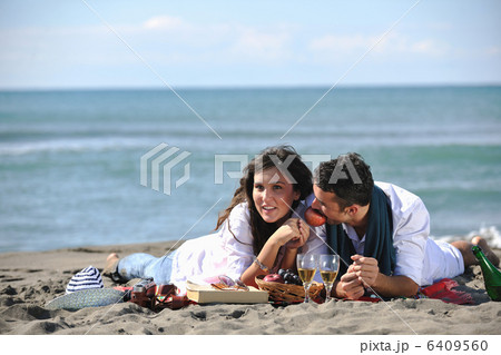 young couple enjoying picnic on the beach 6409560