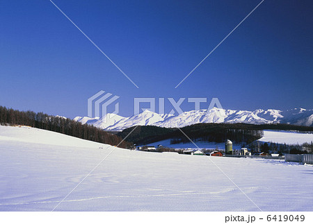 純白の十勝岳と牧場 6419049
