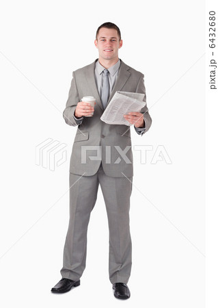 Portrait of a businessman holding a newspaper and a cup of coffe Portrait of a businessman holding a newspaper and a cup of coffe 6432680