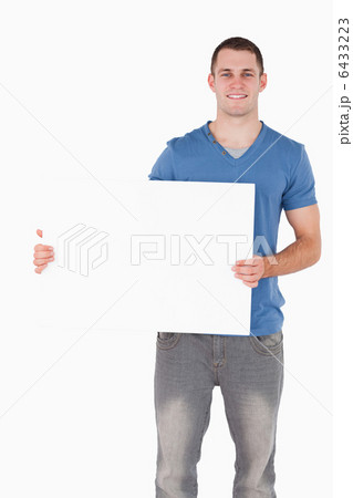 Portrait of a young man holding a blank panel Portrait of a young man holding a blank panel 6433223