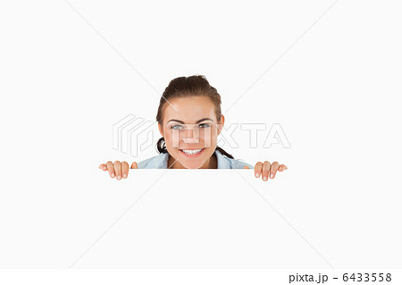 Smiling businesswoman looking over wall 6433558