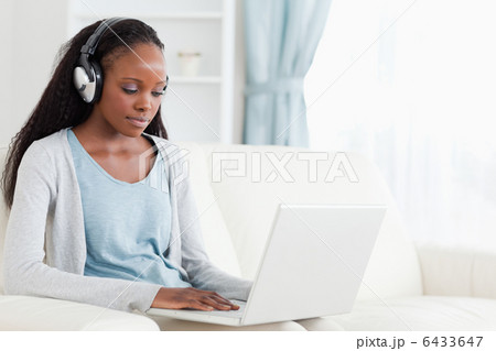 Woman with headphones on working on laptop 6433647