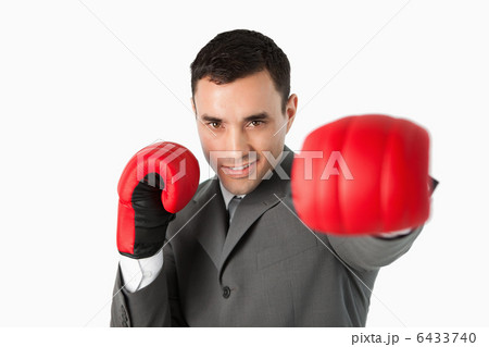 Businessman with boxing gloves on beating 6433740