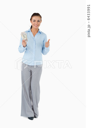 Smiling businesswoman with banknotes giving thumb up 6433991
