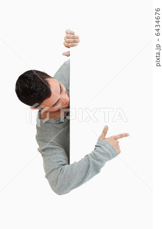 Young male pointing around the corner 6434676