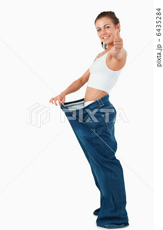 Portrait of a fit woman wearing too large pants with the thumb u Portrait of a fit woman wearing too large pants with the thumb u 6435284