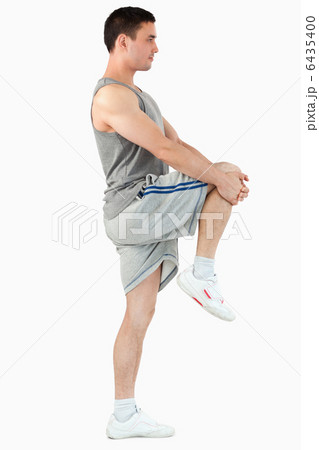 Portrait of a young man stretching his leg Portrait of a young man stretching his leg 6435400