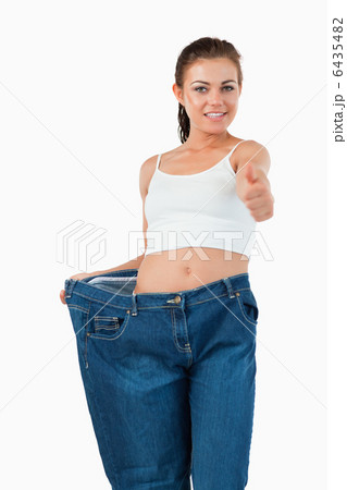 Portrait of a fit woman wearing too large jeans with the thumb u Portrait of a fit woman wearing too large jeans with the thumb u 6435482