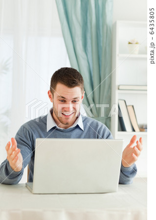 Businessman surprised about his laptop in his homeoffice 6435805
