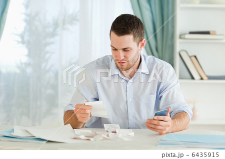 Businessman with calculator checking bills 6435915