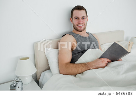 Smiling man reading a novel 6436388