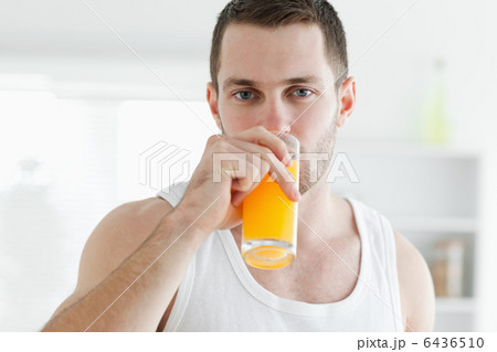 Serene man drinking orange juice Serene man drinking orange juice 6436510