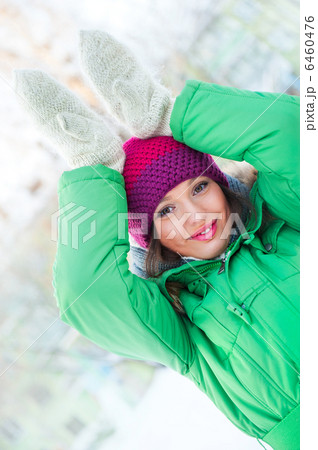 Young beautiful woman wearing winter clothing and playing outdoo 6460476