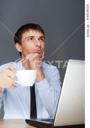 Portrait of a businessman drinking his beverage and daydreaming 6460609