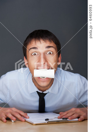 Closeup portrait of business man holding business card in his mo Closeup portrait of business man holding business card in his mo 6460993