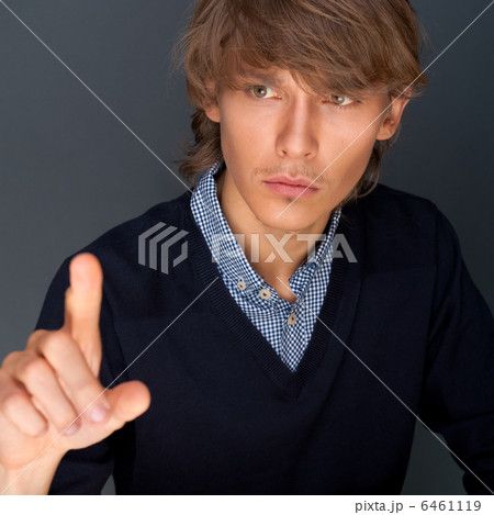 Young business man pressing a touchscreen button while working a Young business man pressing a touchscreen button while working a 6461119