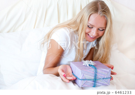 Bedroom surprise present - young happy woman in bedroom 6461233
