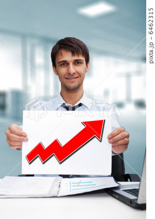 Attractive man in business suit with sign of up graph sitting at Attractive man in business suit with sign of up graph sitting at 6462315