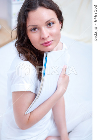 Young woman with a notebook studying at home sitting relaxed on Young woman with a notebook studying at home sitting relaxed on 6463103