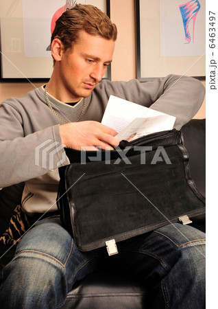 Happy young man sitting on sofa at home 6463497