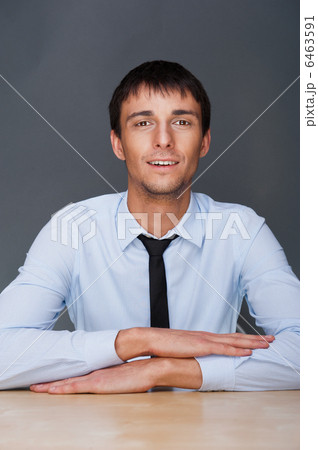 Portrait of young business man on a desk. He is sitting at his n 6463591
