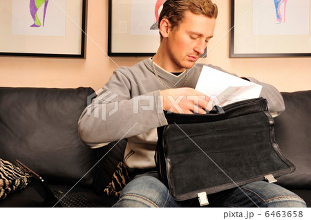 Happy young man sitting on sofa at home 6463658