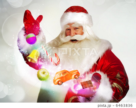 Santa Claus getting gifts and confection from his bag and showin Santa Claus getting gifts and confection from his bag and showin 6463836