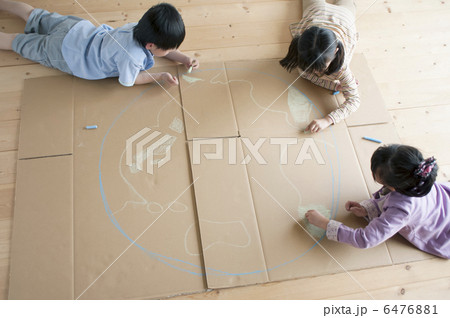 段ボールに地球の絵を描く子供たちの写真素材