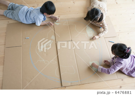 段ボールに地球の絵を描く子供たちの写真素材