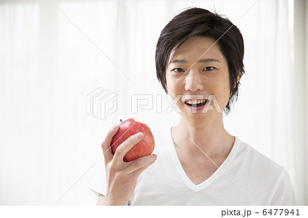 リンゴを持つ若い男性の写真素材