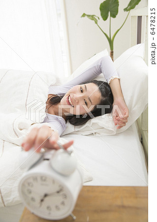 ベットで目覚める若い女性 6478215