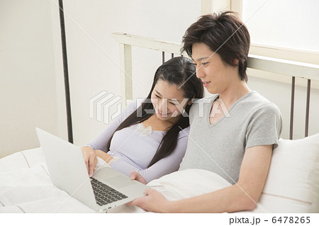 ベットでくつろぐ若いカップル 6478265