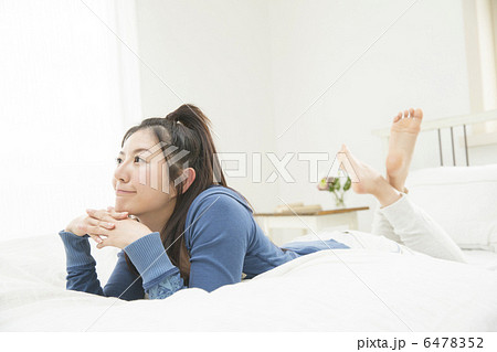 ベットでくつろぐ若い女性 6478352