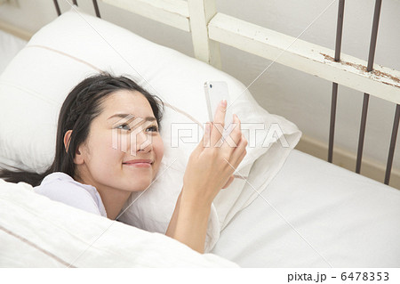 ベットでくつろぐ若い女性 6478353