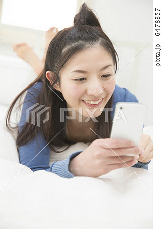 ベットでくつろぐ若い女性 6478357