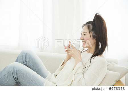 ソファでくつろぐ若い女性 6478358