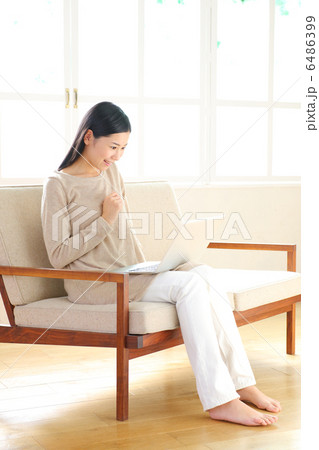 ソファに座ってノートパソコンを使う女性 ソファに座ってノートパソコンを使う女性 6486399